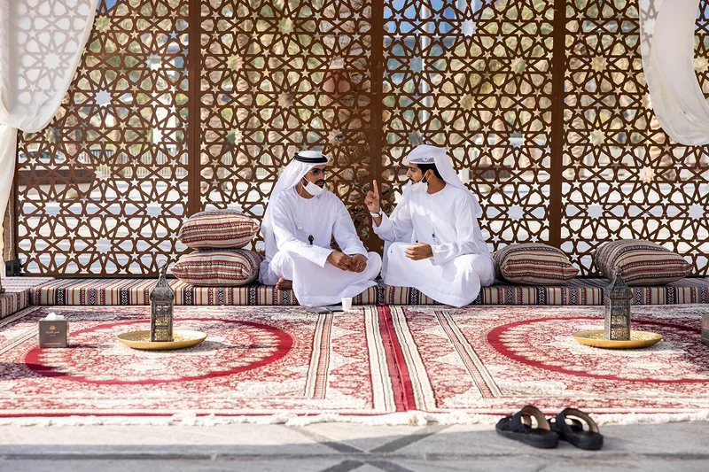 Curved ADNOC employee gallery displaying portraits and personal stories beneath UAE flags