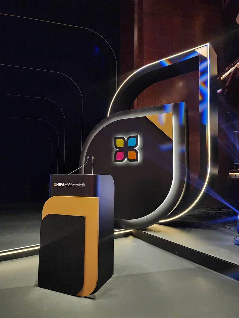 Evolution Scenic HIPA award ceremony podium with illuminated sculptural backdrop and integrated stage lighting