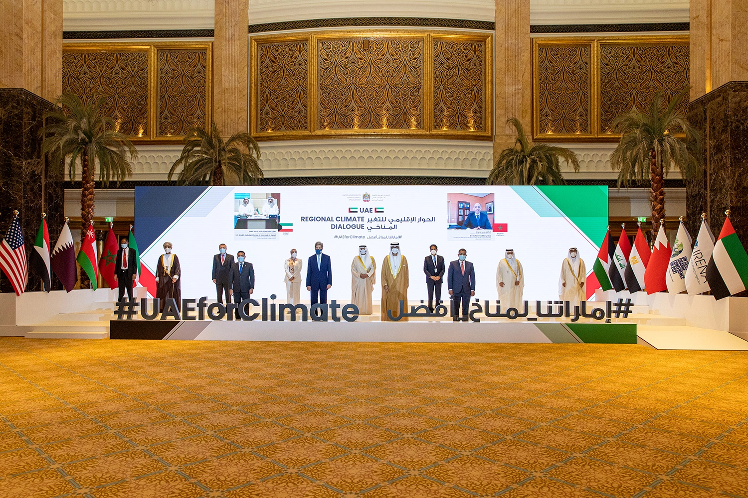 UAE Regional Climate Dialogue plenary setup with branded backdrop, delegate table and national flags