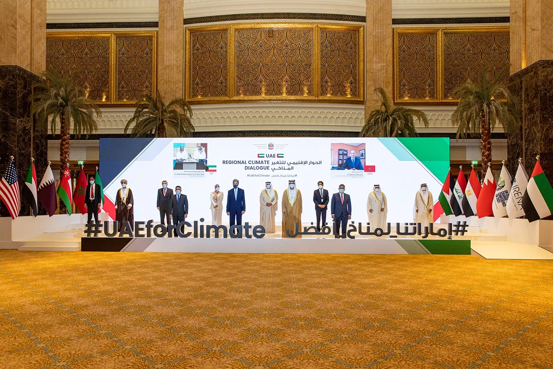 UAE Regional Climate Dialogue plenary setup with branded backdrop, delegate table and national flags