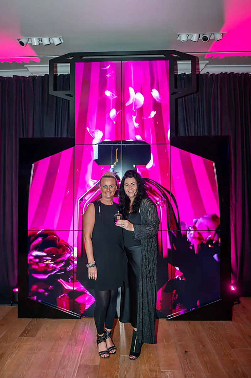 Influencers posing at branded media photo wall during exclusive Dubai fragrance launch